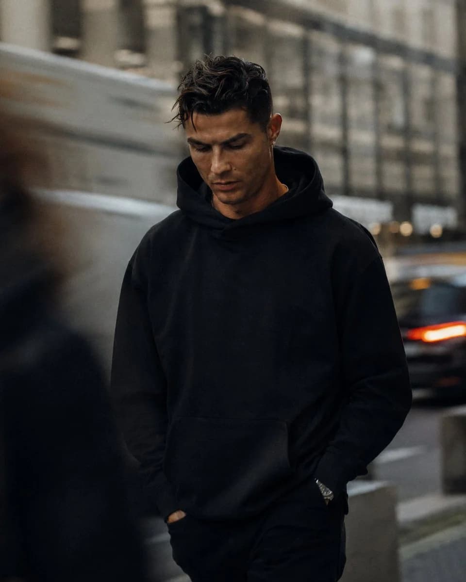 A cinematic street-fashion portrait of a handsome man in oversized clothing, with documentary realism and urban daylight atmosphere