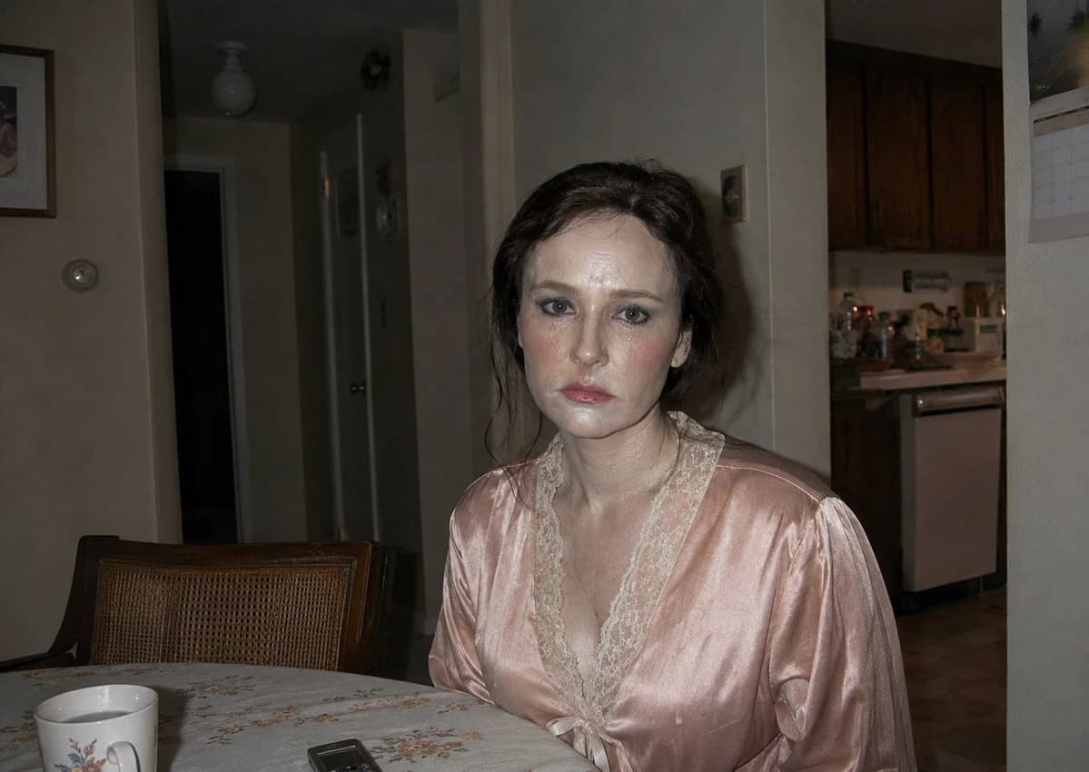 Flash-lit apartment portrait in a dim night interior, with documentary framing and intimate cinematic realism.
