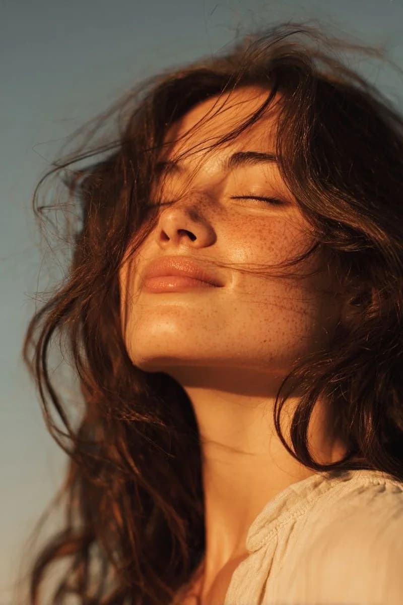 Ultra-realistic golden hour portrait of a young woman with natural skin textures and cinematic lighting