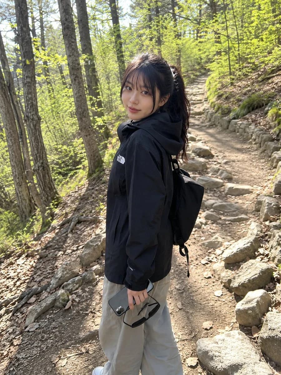 Candid mobile hiking snapshot with casual outdoor outfit, forest trail setting, and natural social-media realism