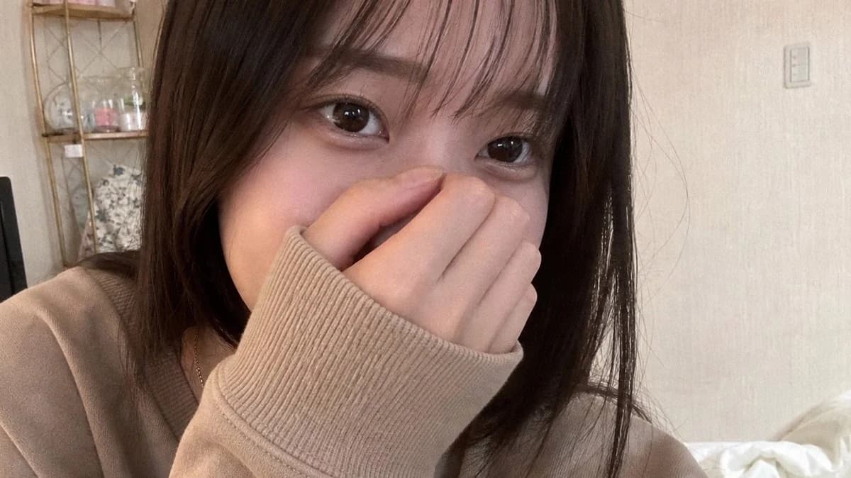 Realistic shy bedroom selfie portrait with soft indoor lighting, natural skin texture, and a candid smartphone-photo mood.